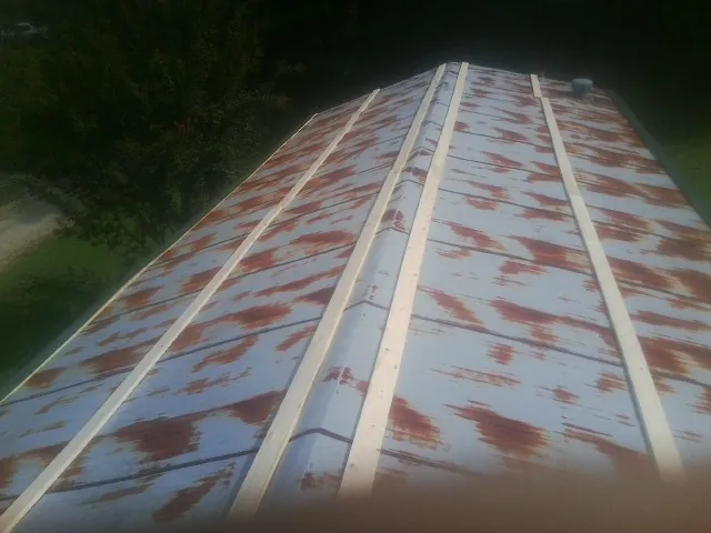 Rusted metal roof panels with new wood purlins before replacement — Storm Damage Roof Repair in Lavon by Roofing Brothers