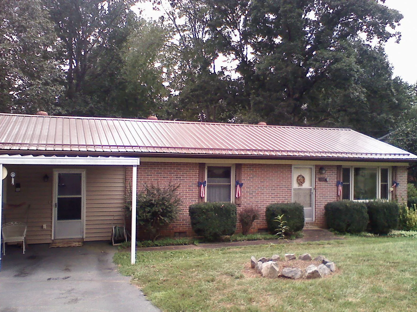 Bronze metal roof and carport on a brick ranch home — Roof Repair work by our crew in Lavon